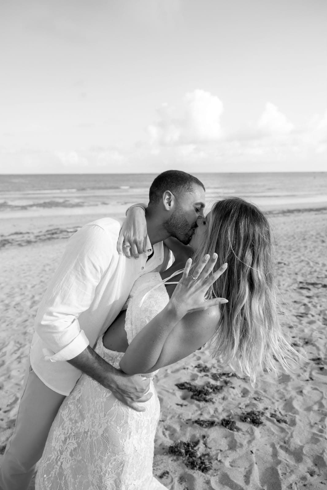 Beijo na praia com Camila mostrando o anel, em preto e branco